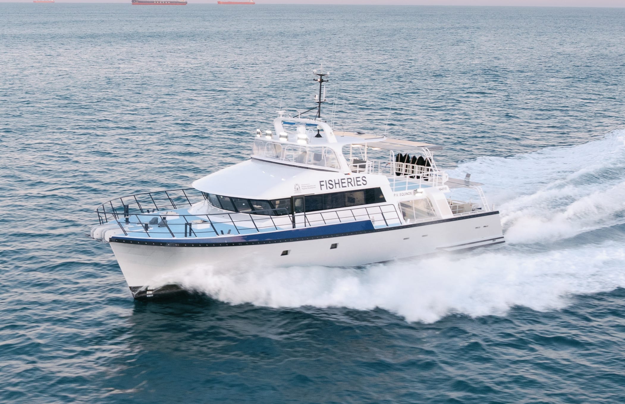 PV Equinox fisheries patrol vessel underway at first light, seen from the port bow quarter with bow spray and a trailing wake.