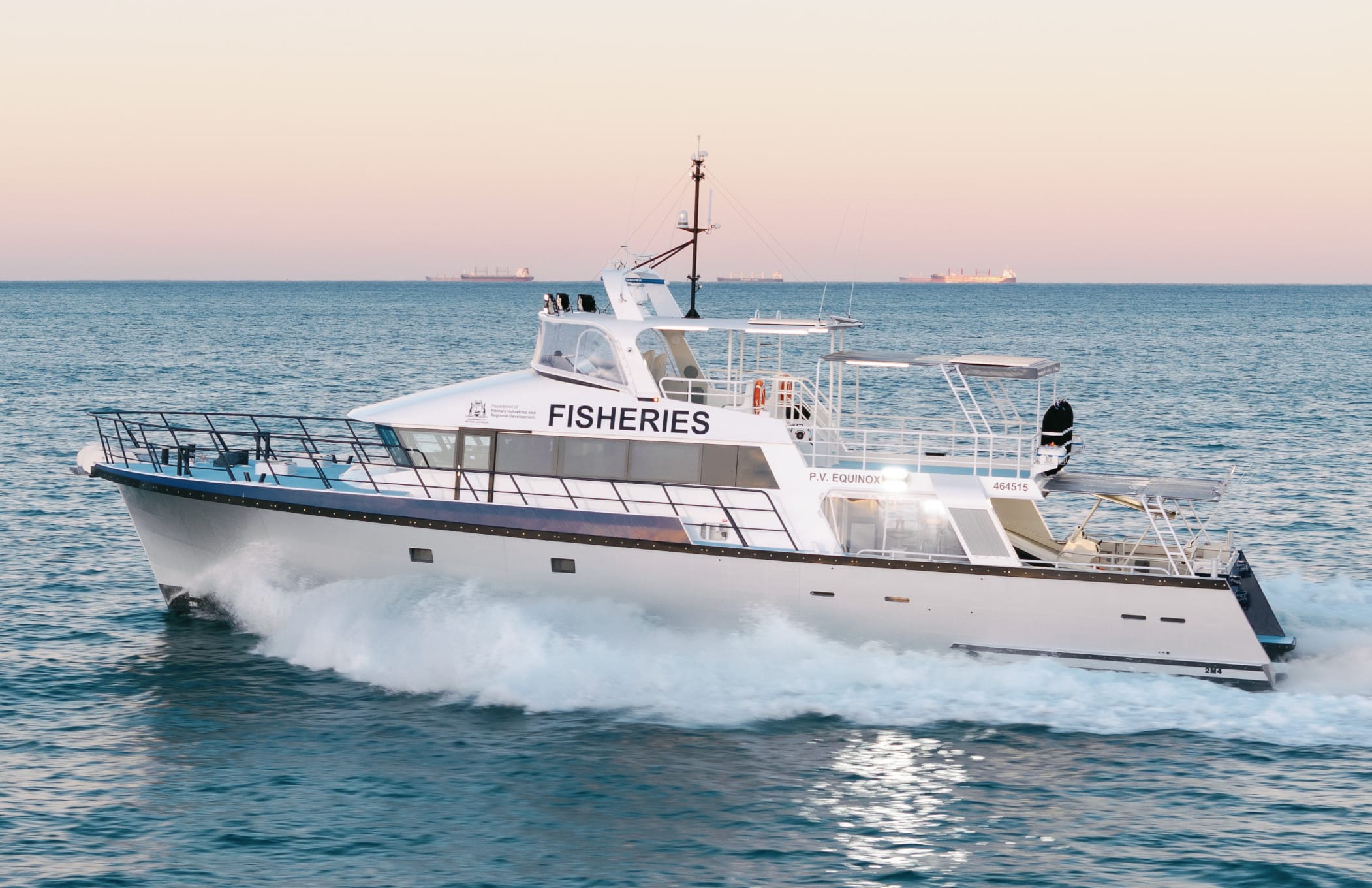 Close port-side view of PV Equinox underway at first light, with Fisheries markings, wheelhouse, flybridge and bow spray visible.